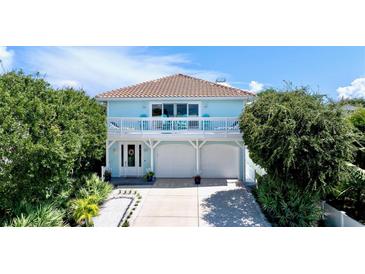 Two-story light blue house with white trim, two-car garage, and balcony at 6345 River Rd, New Smyrna Beach, FL 32169