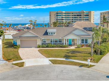 Single-story home with ocean views, light-colored siding, and a paved driveway at 91 Maura Ter, Ponce Inlet, FL 32127