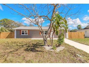 Charming single-story home featuring neutral stucco, white trim, and a tidy front yard with simple landscaping at 1935 Fern Palm Dr, Edgewater, FL 32141