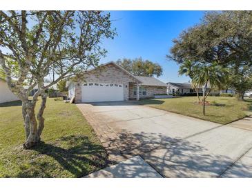 Charming brick home featuring a well-maintained lawn and a spacious two-car garage at 234 Meadow Lake Dr, Edgewater, FL 32141