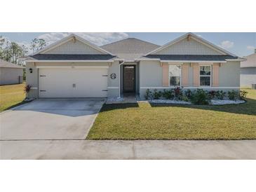Charming single-story home features a well-manicured lawn, inviting entrance, and two-car garage at 301 Sunset Point Dr, Ormond Beach, FL 32174