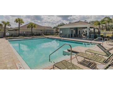 Community pool with sun loungers and covered pavilion area for residents enjoyment at 301 Sunset Point Dr, Ormond Beach, FL 32174