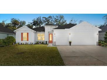 Charming home featuring a well-manicured lawn, neutral palette, and a two-car garage at 3029 Adrian Dr, Ormond Beach, FL 32174