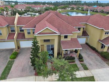 A beautiful aerial view of the townhomes, red roofs, and a fountain in the lake at Venetian Bay at 3546 Casalta Cir, New Smyrna Beach, FL 32168