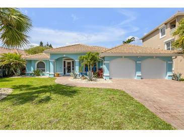 Charming light blue home with well-manicured lawn, brick driveway, and two-car garage at 3728 Egret Dunes Dr, Ormond Beach, FL 32176