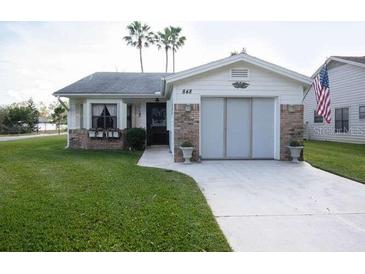 Lovely single-story home showcasing a well-manicured lawn, charming flower boxes, and an attached garage at 848 Pine Shores Cir, New Smyrna Beach, FL 32168