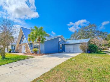 Unique home featuring a metal roof, stone accents and a long driveway at 950 Sand Crest Dr, Port Orange, FL 32127
