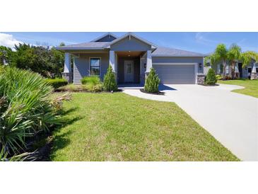 Charming single-story home with a manicured front yard and a gray exterior at 1100 Loch Linnhe Ct, New Smyrna Beach, FL 32168