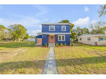 Charming two-story home featuring a walkway to the front door and a well-manicured lawn at 118 E Palm Way, Edgewater, FL 32132