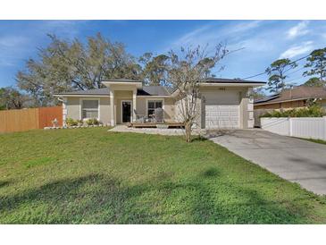 Charming single Gathering home with attached garage, nice front yard, and a small front porch at 1462 General Mcarthur Ave, Daytona Beach, FL 32124