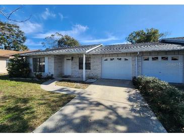 Charming single-story home with brick facade, attached garage, and well-maintained front yard at 311 Sea Hawk Ct, Edgewater, FL 32141