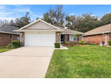 Charming single-story home with a well-manicured lawn and a two-car garage at 634 Coral Trace Blvd, Edgewater, FL 32132