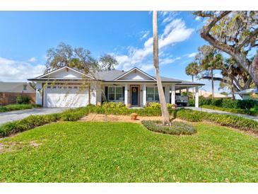 Charming single-story home featuring a well-manicured lawn and inviting front porch at 105 Azalea Cir, New Smyrna Beach, FL 32168