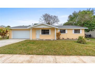Charming single-story home with a well-manicured lawn and attached two car garage at 2211 Brian Ave, South Daytona, FL 32119