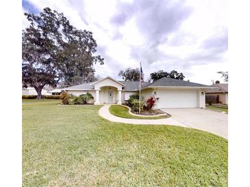 Charming single-story home with a well-manicured lawn and an inviting walkway to the front door at 2307 Needle Palm Dr, Edgewater, FL 32141