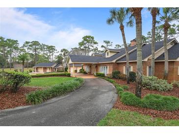 Charming brick home with a long driveway, mature trees, and beautifully landscaped front yard at 2333 Southern Pines Pl, Deland, FL 32724
