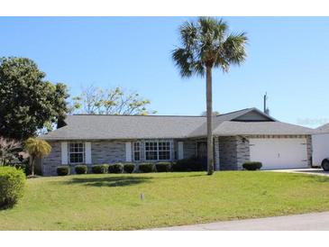 Charming single-story home featuring a well-maintained yard and a two-car garage at 2409 Victory Palm Dr, Edgewater, FL 32141