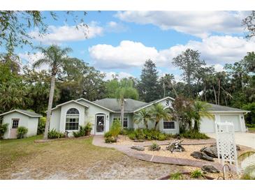 Charming single-story home with lush landscaping and a stone pathway leading to the front door at 2576 Shilo Glynn Ln, New Smyrna Beach, FL 32168