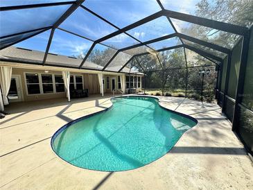 Outdoor screened in pool with patio furniture and blue water at 3435 Black Willow Trl, Deland, FL 32724