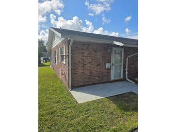 Exterior view of the brick house showcasing its charming curb appeal and well-maintained lawn on a sunny day at 36 Fairway Ct # 36, Deland, FL 32724