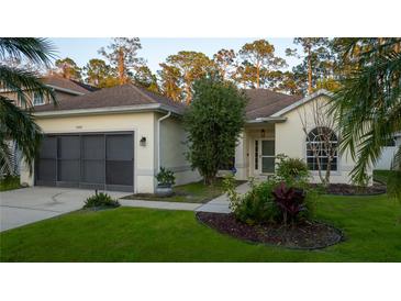 Charming single-story home featuring a well-manicured lawn and a two-car garage at 5424 Frederick Lake Dr, Port Orange, FL 32128