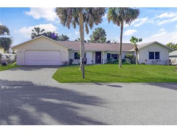 Charming single-story home with lush landscaping and a well-manicured lawn at 55 Bay Harbour Dr, Ponce Inlet, FL 32127
