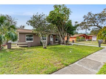 Charming single-story home with a well-maintained lawn and lush landscaping at 612 Cedar Park Dr, Daytona Beach, FL 32114