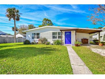 Charming single-story home featuring a bright blue front door and well-maintained lawn at 902 Conrad Dr, New Smyrna Beach, FL 32168