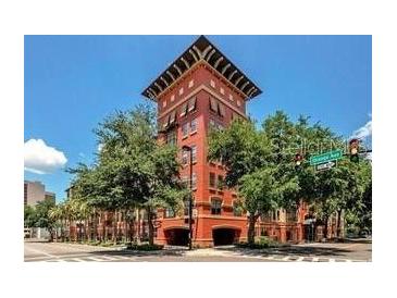 Exterior showcases a brick building featuring unique architecture and lush green trees at 911 N Orange Ave # 528, Orlando, FL 32801