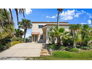 Inviting home with a well-kept lawn, mature palm trees, and a concrete driveway leading to the front entrance at 2901 Hill St, New Smyrna Beach, FL 32169