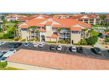 Beautiful condominium complex featuring lush landscaping, a terracotta roof, and ample parking at 407 Bouchelle Dr # 205, New Smyrna Beach, FL 32169