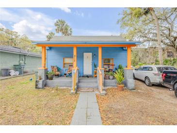 Charming blue home with orange trim, featuring a cozy front porch and a well-maintained walkway at 812 Marion St, Daytona Beach, FL 32114