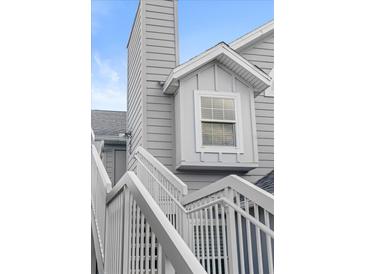 A close up of an exterior home elevation, showing stairs and a window dormer at 898 Baybreeze Way # 880, New Smyrna Beach, FL 32169