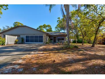 Charming single-story home featuring a screened garage and a well-maintained front yard under a clear blue sky at 68 Crooked Pine Rd, Port Orange, FL 32128