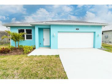 Charming turquoise single-story home with a white garage door, landscaped yard, and a well-lit front entrance at 113 Douglas St, Edgewater, FL 32141