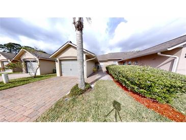 Charming one-story home with a well-manicured lawn, brick driveway, and a one-car garage at 106 Tuscany Villas Dr # 0160, Edgewater, FL 32141