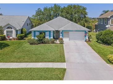 Charming one-story home with well-manicured lawn, mature landscaping and light blue exterior at 1363 Wayne Ave, New Smyrna Beach, FL 32168
