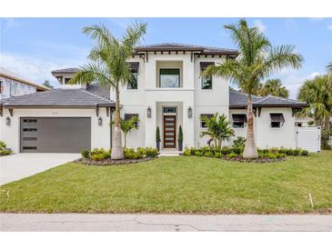 Stunning two-story home with a modern design, lush landscaping, and inviting curb appeal at 212 Due East St, New Smyrna Beach, FL 32169