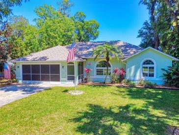 Charming single-story home with well-manicured lawn, mature trees, and an attached two-car garage at 3013 Lime Tree Dr, Edgewater, FL 32141