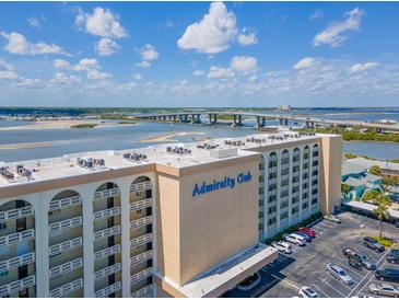 Aerial view of the Admiralty Club condo building, revealing waterfront views and ample parking at 3606 S Peninsula Dr # 703, Port Orange, FL 32127