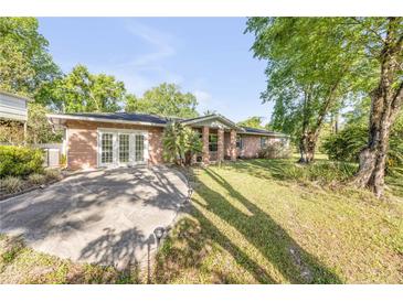 Charming single-story brick home with a well-maintained lawn and mature trees at 416 Western Rd, New Smyrna Beach, FL 32168