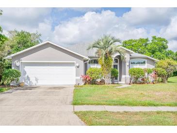Charming single-story home featuring a well-manicured lawn, stucco exterior, and a two-car garage at 6403 Adrianne Ct, Port Orange, FL 32128