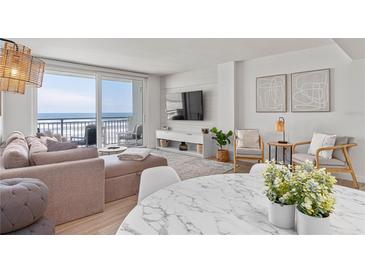 Bright living room featuring a large sectional sofa and sliding glass doors with ocean views at 705 N Atlantic Ave # 4030, New Smyrna Beach, FL 32169