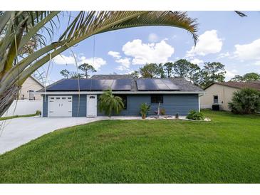 Charming home featuring solar panels, a well-manicured lawn, and a convenient two-car garage at 2797 Nordman Ave, New Smyrna Beach, FL 32168