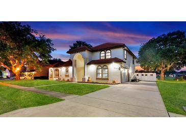 Stunning two-story home featuring a red tile roof, a well-manicured lawn, and a spacious driveway at sunset at 2813 Ballard Ave, Orlando, FL 32833