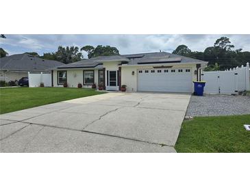 Charming single-story home with solar panels, two-car garage, and a well-maintained lawn at 2820 Tamarind Dr, Edgewater, FL 32141