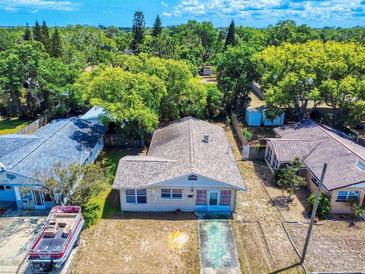 A quaint one-story home featuring neutral siding, a compact front yard, and a boat parked nearby at 310 Legion Pl, Port Orange, FL 32129