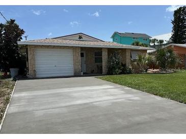 Charming single-story home featuring a garage and a well-maintained front yard with lush green grass at 4219 Oriole Ave, Port Orange, FL 32127