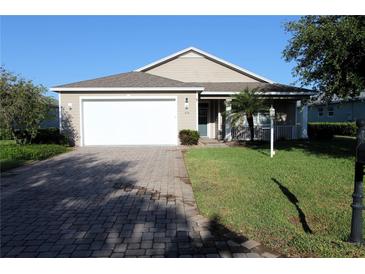 Charming single-story home with a brick driveway, two car garage, and manicured front lawn at 436 Eldora Dr, Oak Hill, FL 32759