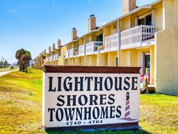 Prominent 'Lighthouse Shores Townhomes' sign near residences and ocean access enhances property appeal at 4752 S Atlantic Ave # 1, Ponce Inlet, FL 32127